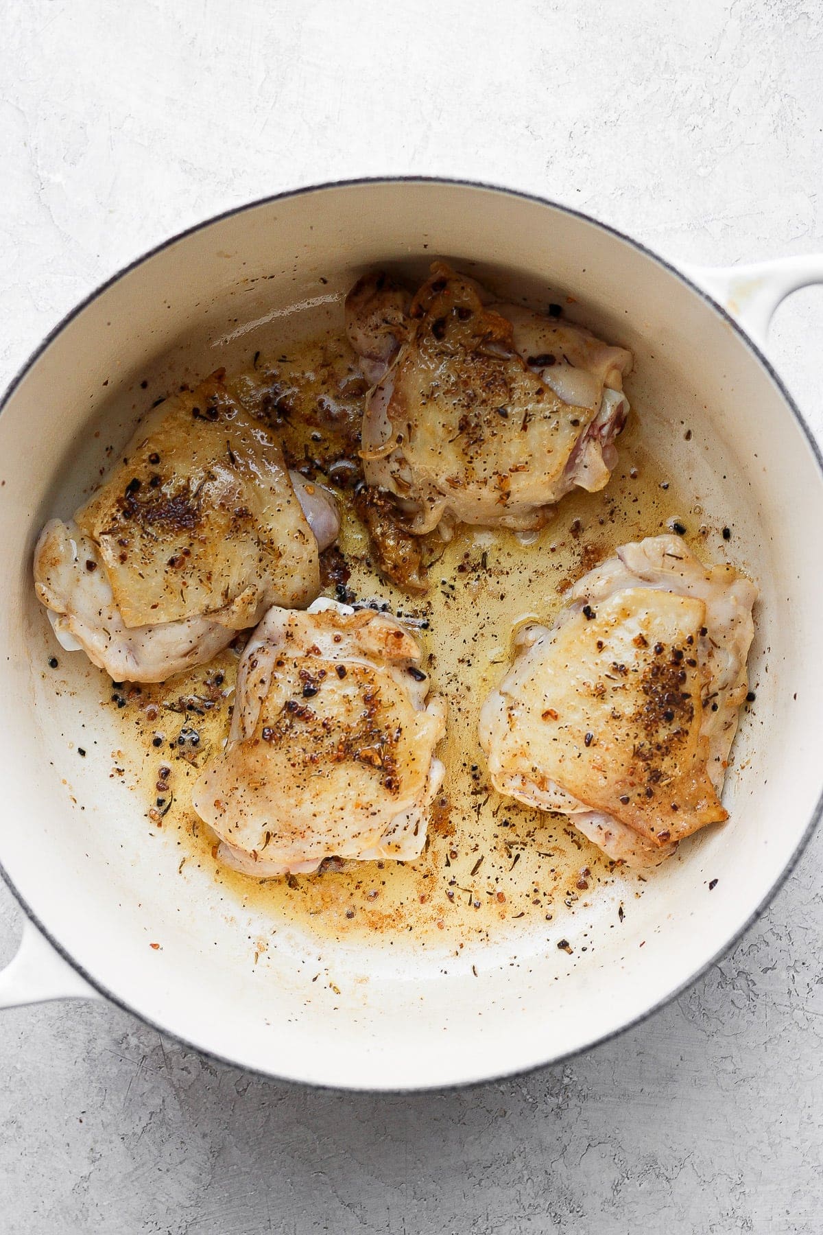 A flavorful chicken and rice recipe made with juicy chicken thighs and the most flavorful rice medley you've ever had! And, yes, it includes tons of veggies! sautéed chicken thighs in Dutch oven.