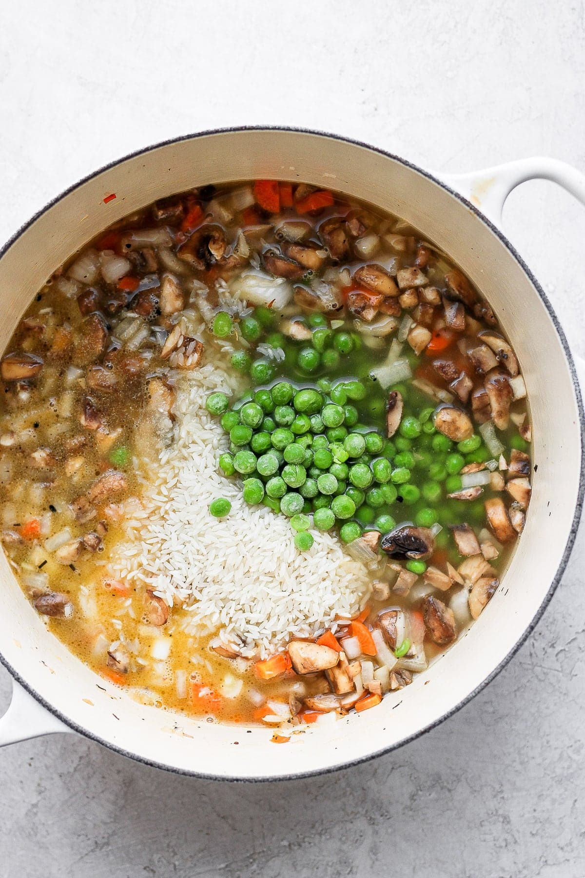 A flavorful chicken and rice recipe made with juicy chicken thighs and the most flavorful rice medley you've ever had! And, yes, it includes tons of veggies! rice and veggies in stockpot.