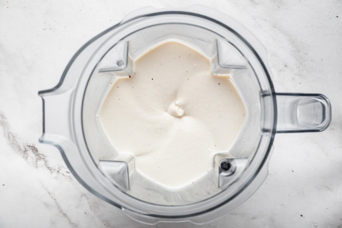 Cottage cheese french onion dip in the base of a blender all smooth and creamy.