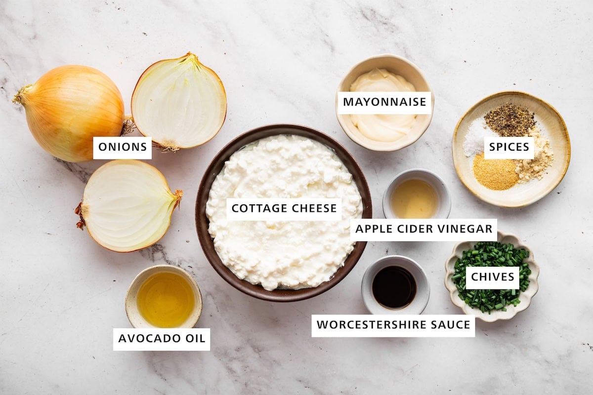 Ingredients measured out for french onion dip: cottage cheese, mayonnaise, apple cider vinegar, worcestershire sauce, chives, spices, avocado oil, and onions.